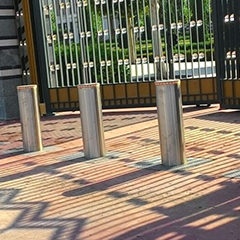 image of automatic stainless steel bollards with brushless motor installed in front of a company's gate