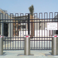 semiautomatic stainless steel bollard with integrated flashing light installed at a school gate
