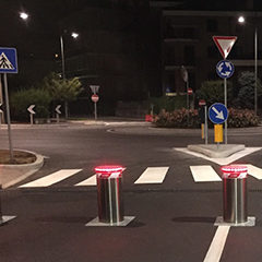 image of automatic bollards in stainless steel with integrated flashing lights positioned to close the entrance to a supermarket car park