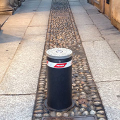 picture of removable bollards with flashing light integrated located in a city center street to prevent the passage of cars